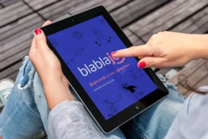 zdjęcie pokazuje tablet, na którego ekranie wyświetla się okładka ebooka poradnika "Bezpieczeństwo w sieci, cyberprzemoc". Poradnik dla rodziców o bezpieczeństwie dzieci w sieci od Blablajoy